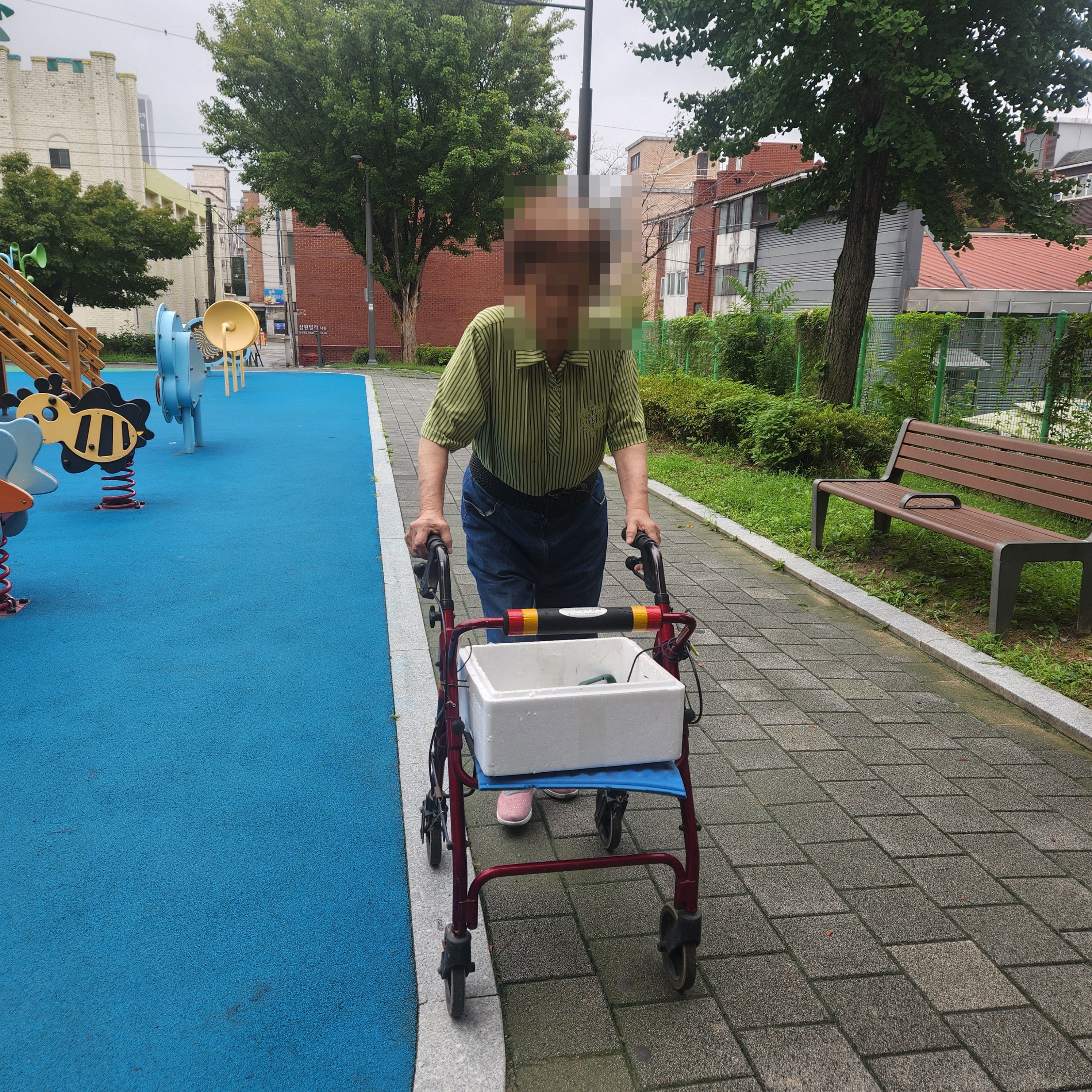 보행보조기를 사용해 야외를 이동하는 어르신